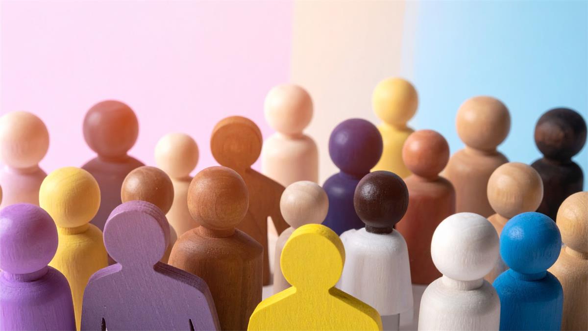 Multicultural Wooden Figures Standing Together on Pastel Background